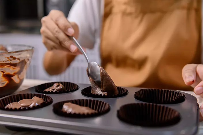 woman making cupcakes in a pan
