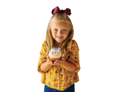 girl holding a cow shaped cupcake 