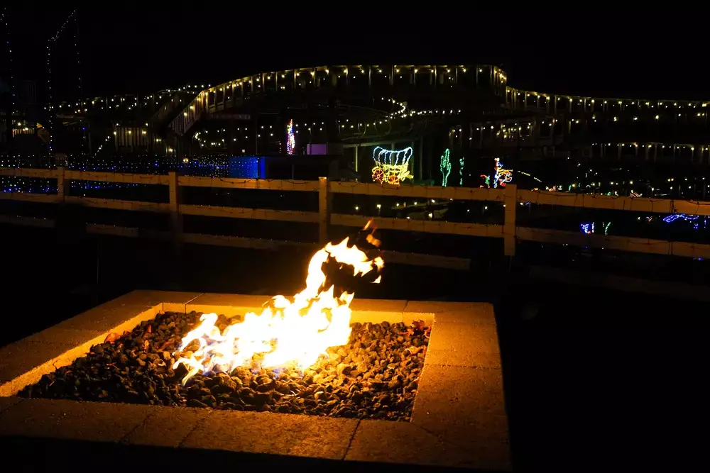 fire pit with SkyLand's Festival of Lights displays in background